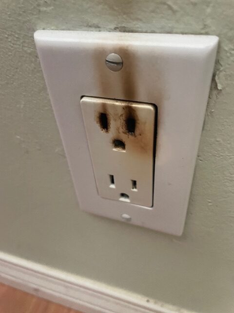 Ready Electric electrician inspecting an outlet with a burning smell in a Los Angeles home